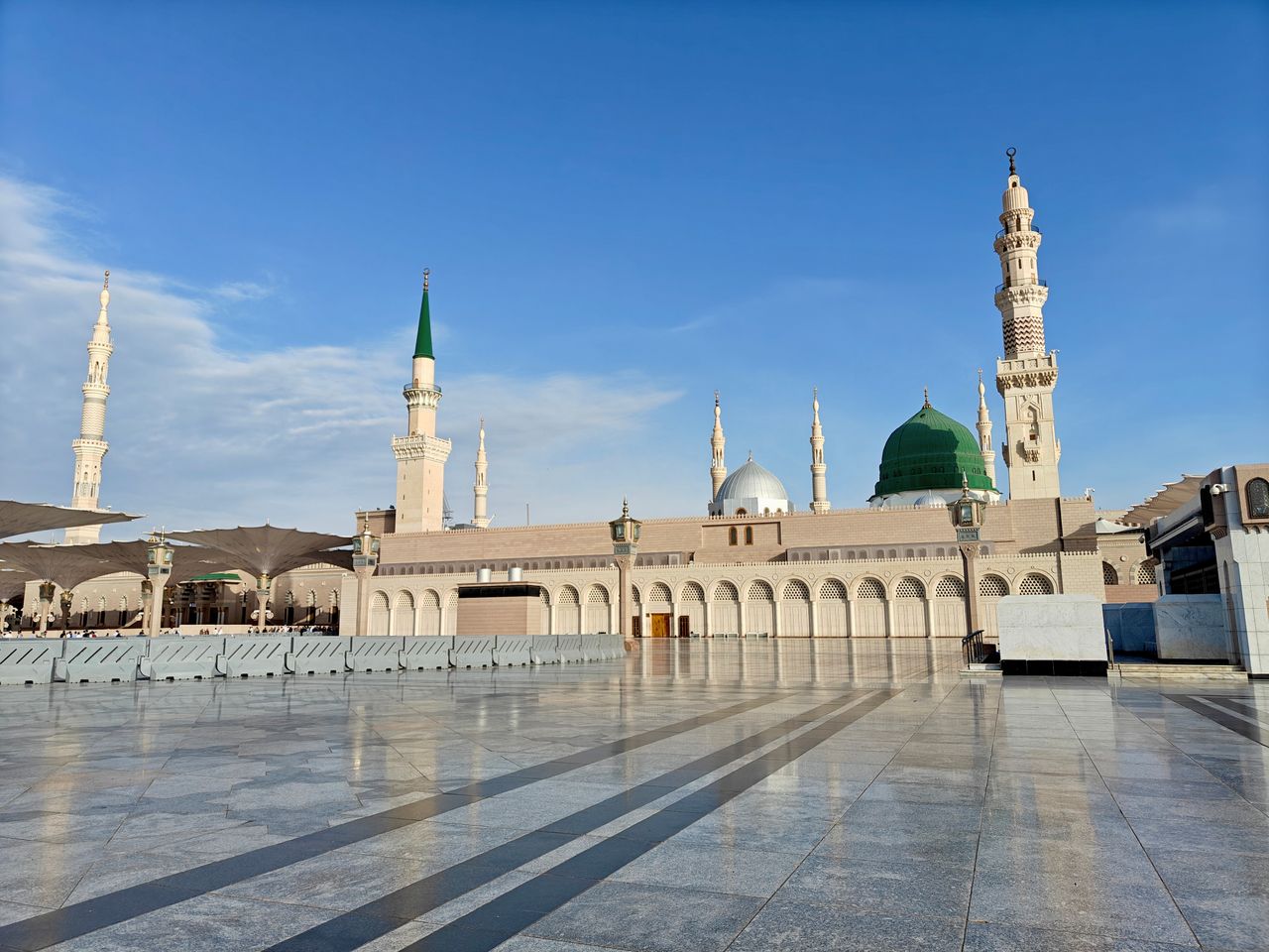 Services Beautiful view of the Masjid an-Nabawi in Medina with clear blue skies, capturing its iconic domes and minarets.